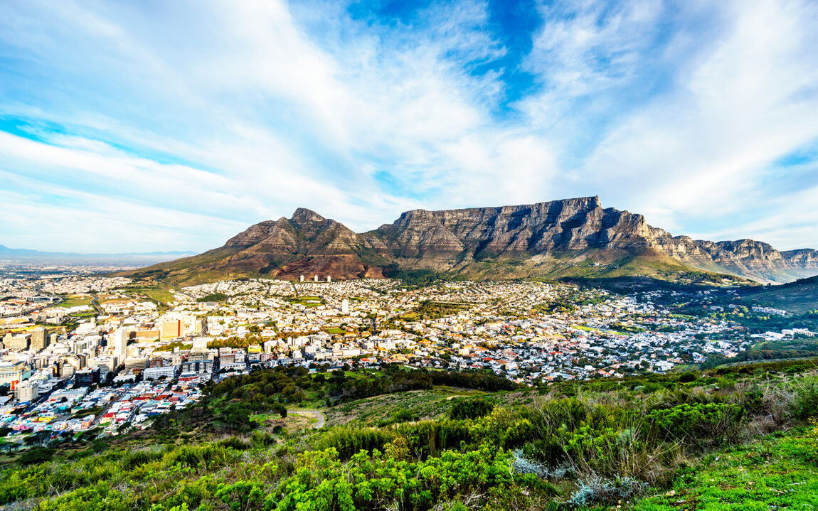 Sun setting over Cape Town, Table Mountain, Devils Peak, Lions Head and the Twelve Apostles. Viewed from the road to Signal Hill at Cape Town, South Africa