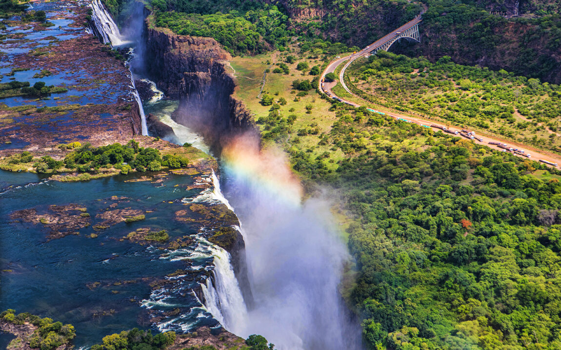 Rainbow over Victoria Falls in Zimbabwe, sunny day in Africa